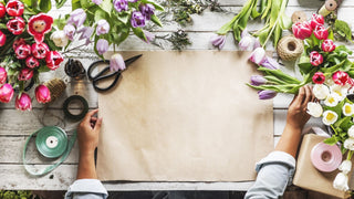 A blank slate with flowers ready to be put together into an arrangement