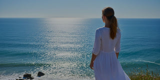 Woman standing alone looking at the ocean, reflecting on relationships, self-respect, and life choices. O