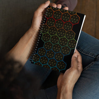 A man holding a geometric designed spiral notebook