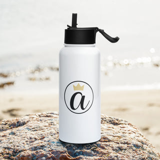 Already Regis® 32 oz stainless steel water bottle featuring crowned “a” emblem, beach background