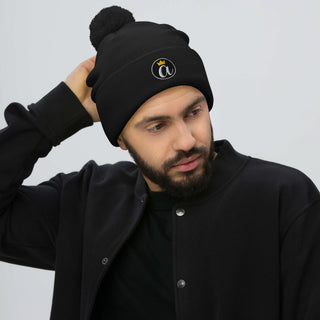 Man wearing the black Already Regis® Crowned Pom-Pom Beanie with embroidered crown design
