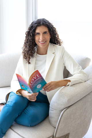 Lisa Eve, founder of The Happy Channel®, holding her book The Love Channel.
