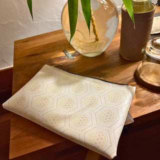 Decorative leather clutch with geometric pattern on a wooden surface