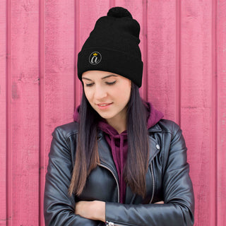 Woman wearing the black Already Regis® Crowned Pom-Pom Beanie with embroidered crown design