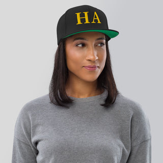 Woman wearing black HA Snapback Hat with gold embroidered HA design